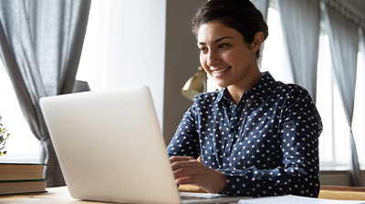 A woman sitting at her desk while using her laptop